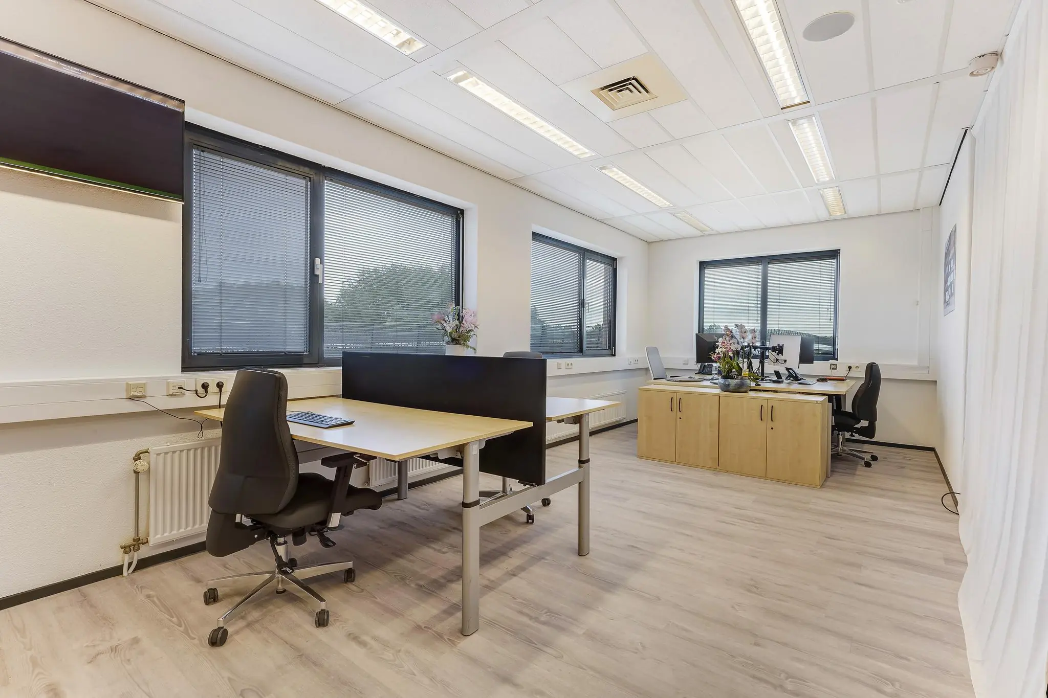 Modern kantoor met meerdere werkplekken, bureaustoelen en grote ramen aan de Laan van ’s-Gravenmade.